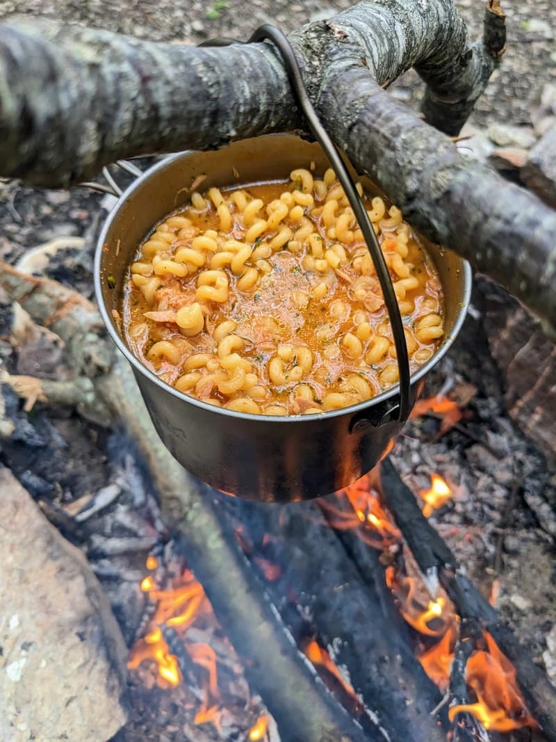 A pot of cavatappi pasta over a fire