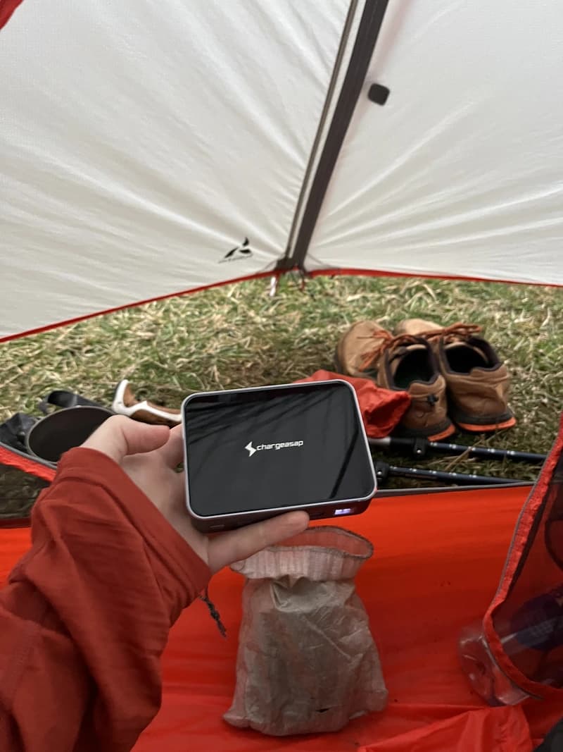 a portable charge in a persons hand within a tent