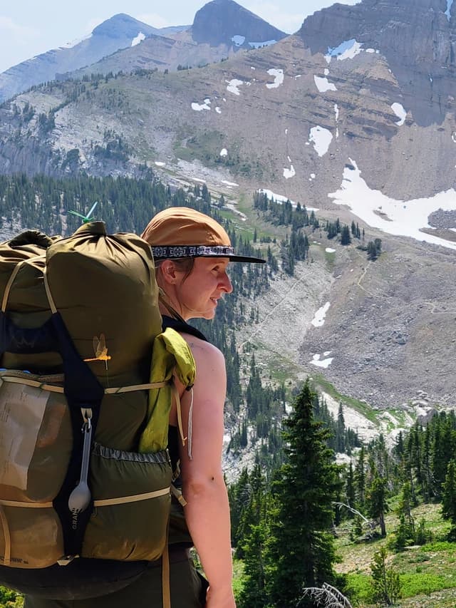 a woman looking over a beautiful mountain scene