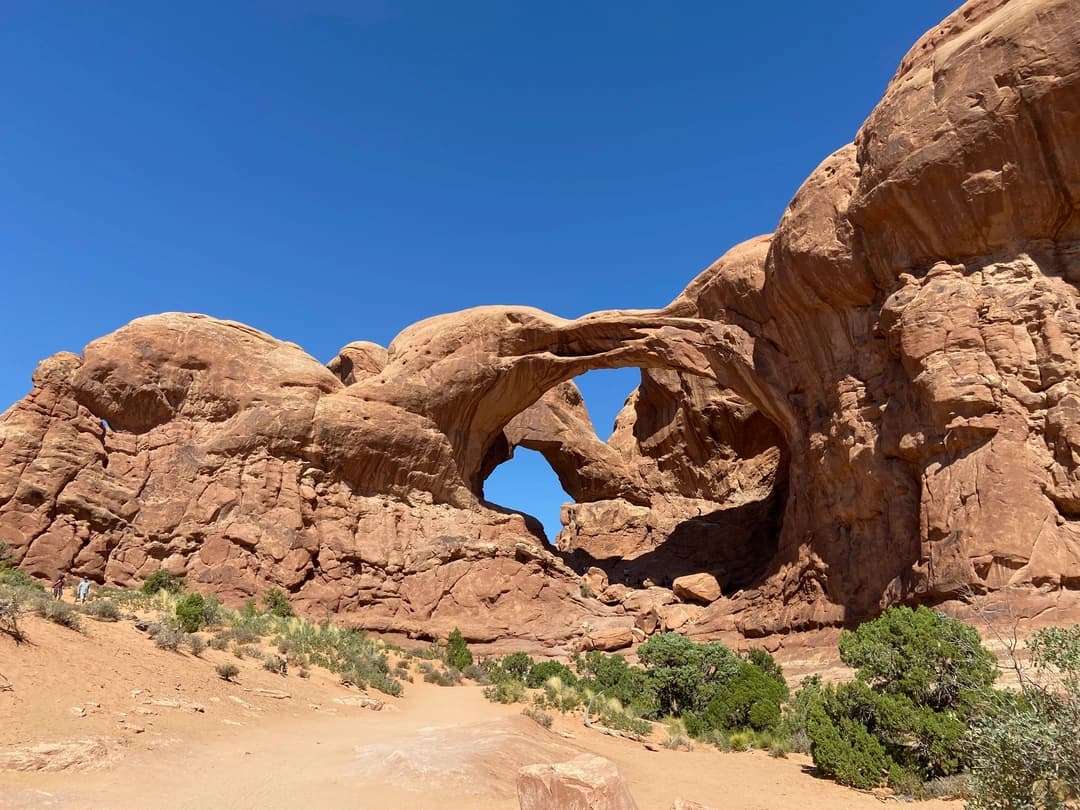 view of arches national park with a rock arch in the foreground
