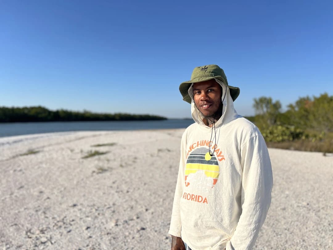 Justin Tucker standing on a sandy beach