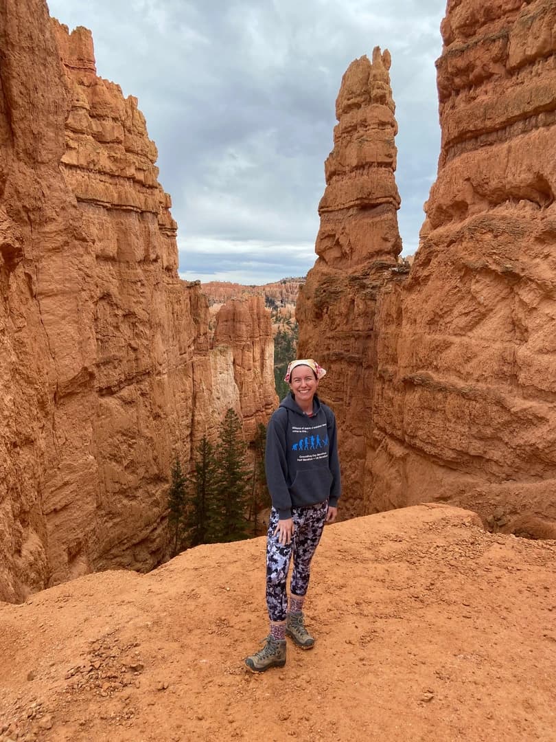 a person standing at the start of the navajo loop trail