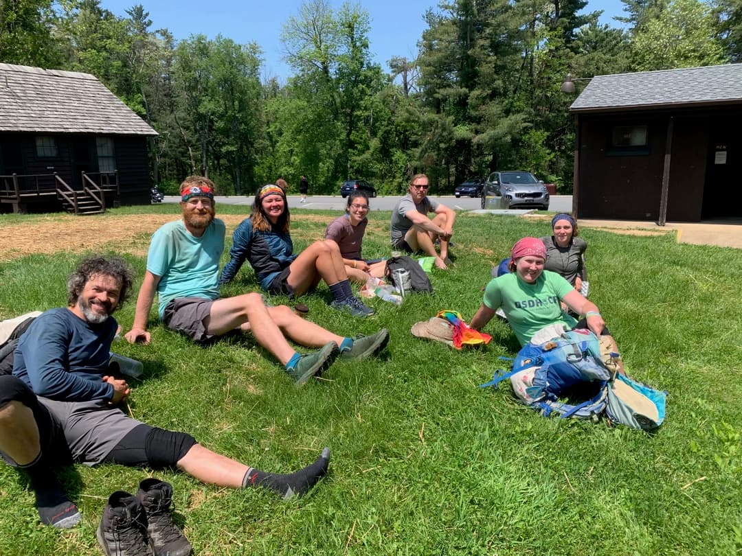 Nicole Kemon sitting on the grass with a group of hikers