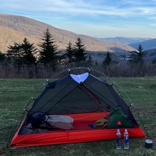 lightweight screen tent setup on a grassy mountain