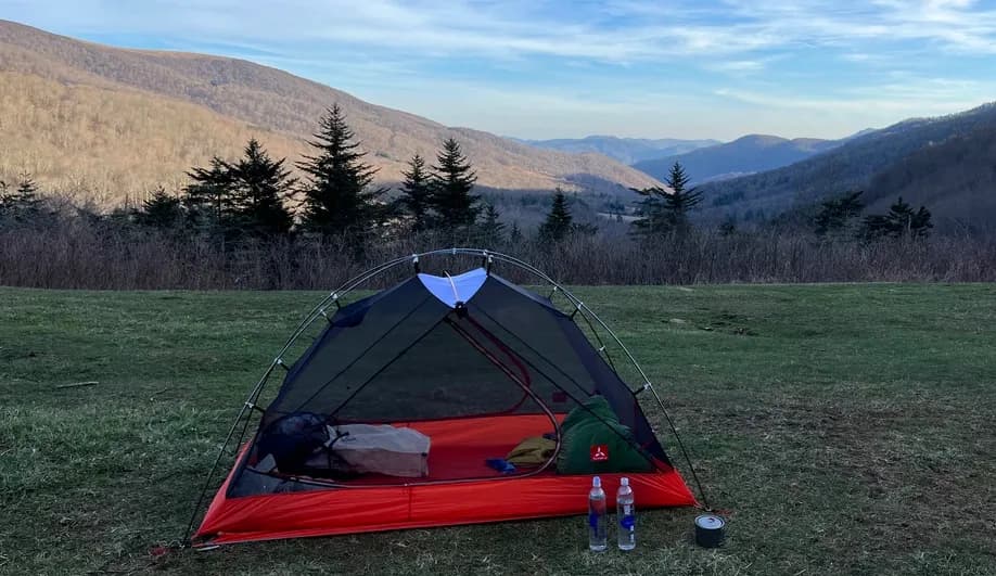 lightweight screen tent setup on a grassy mountain