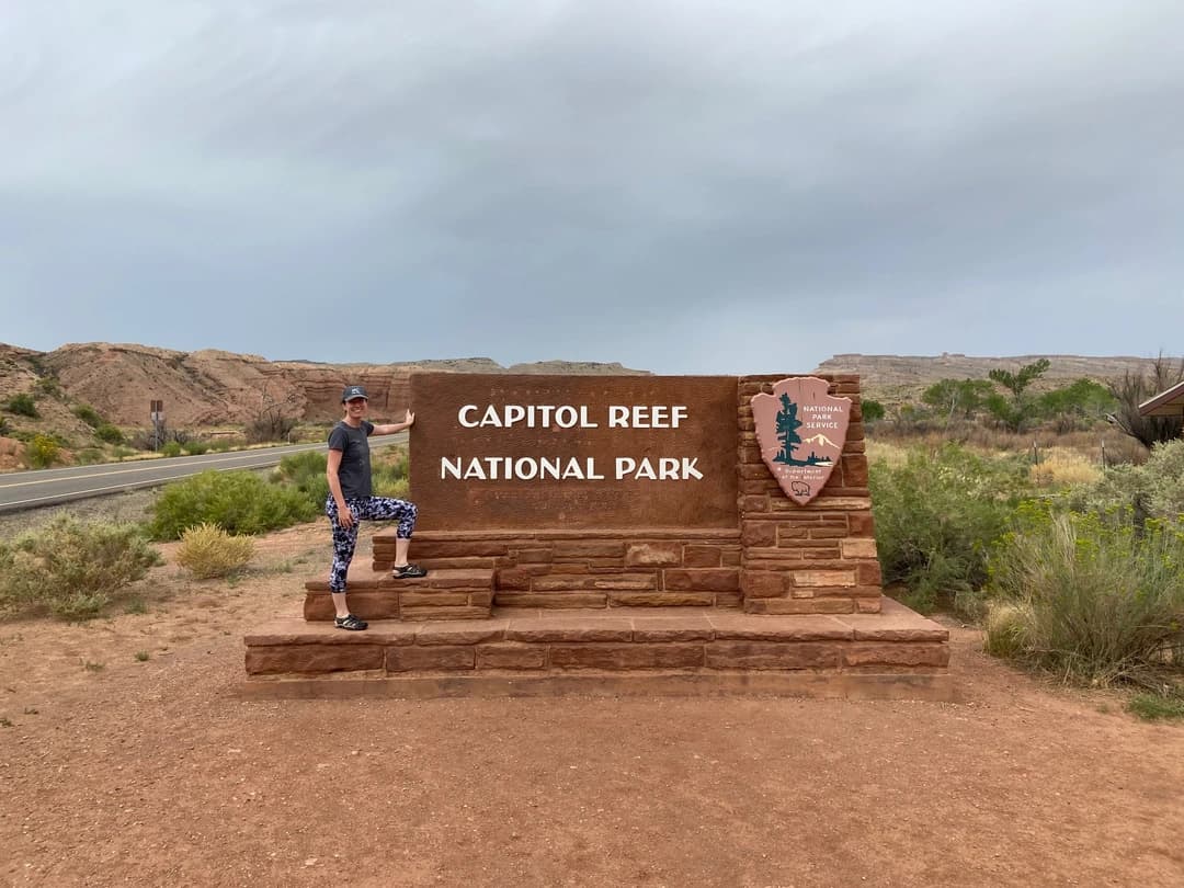 a woman in front of the sign for Capitol Reef National Park