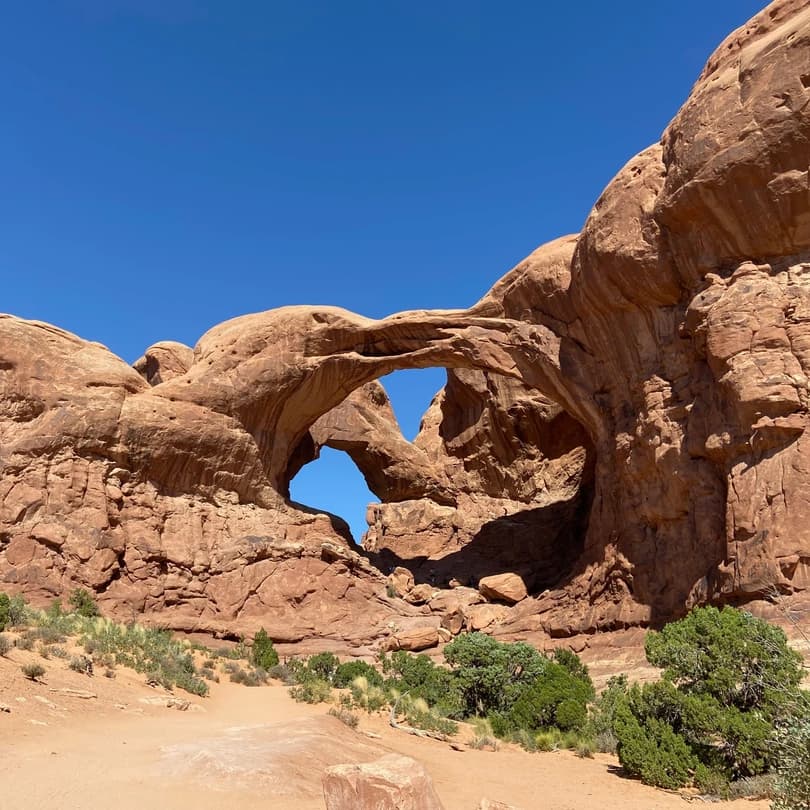 view of arches national park with a rock arch in the foreground
